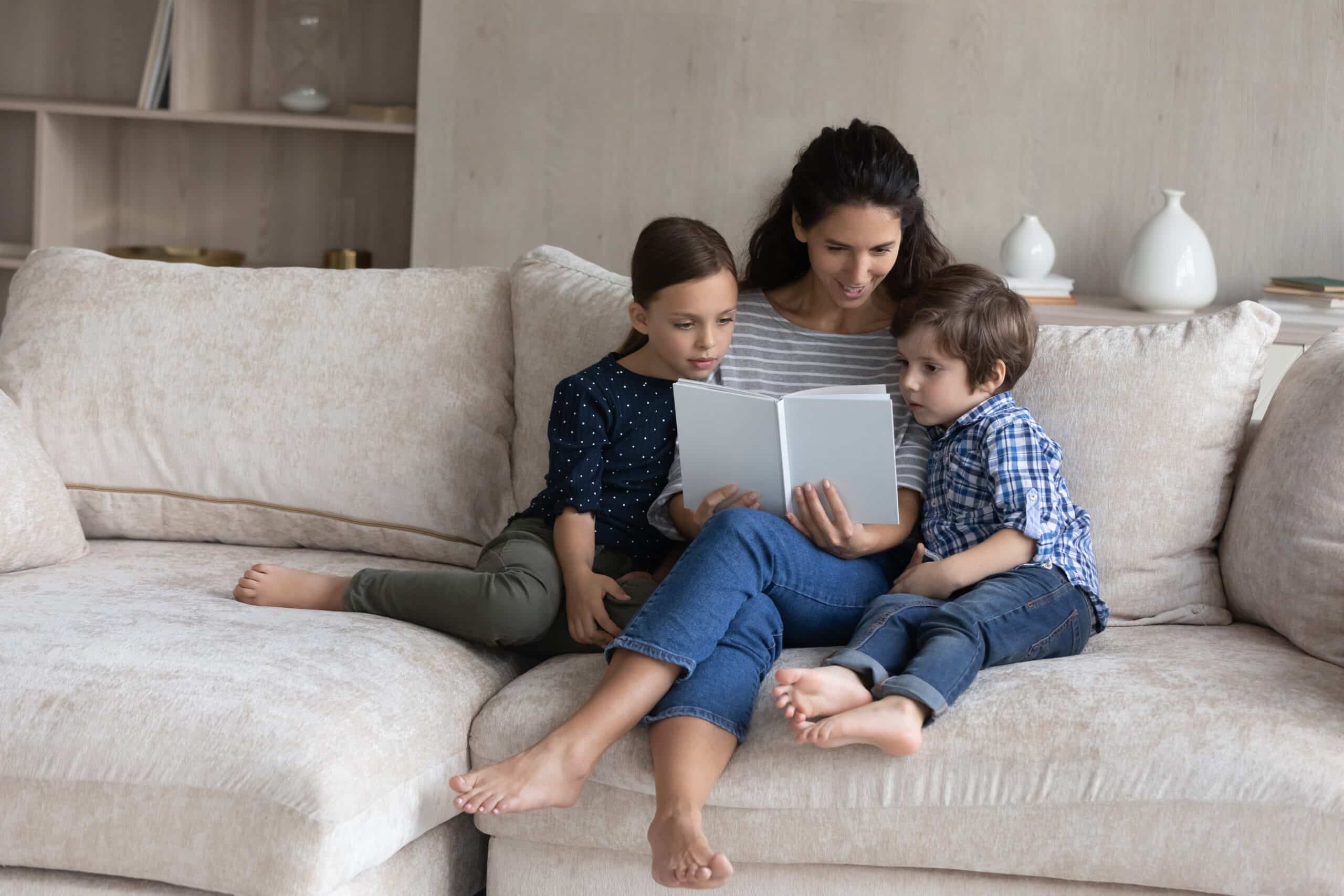 Mom and children sitting on a sofa reading